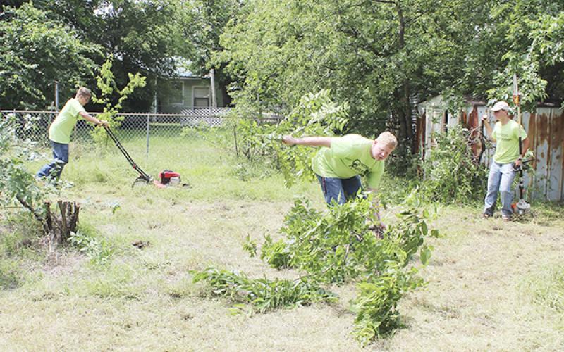 Student volunteers mow, trim trees and remove brush at a property on South 9th Street Saturday as part of Operation Restoration. Organizers from the Jacksboro FFA with participants from several student groups and more, hope to make the community service project an annual event. 