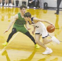 Brayden Rockey (12) drives past the Iowa Park defender as part of second half action Tuesday, Jan. 9 against the Hawks. Rockey and the Tigers remained winless in District 7-3A with a 71-56 loss. Photo/Brian Smith