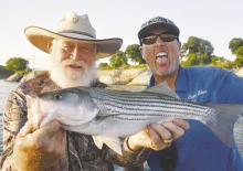Lake Texoma fishing guide Chris Carey, right and Larry Weisenhuhn show off one of the stripers caught during a recent trip with the writer and Jeff Rice. Photo/Luke Clayton