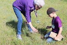 Martha Salmon helps Evan Walker identify a wildflower. Fourth graders spent a portion of the day as junior naturalists — observing, collecting, journaling, drawing and sharing information with classmates on plants they found at Richards Ranch.