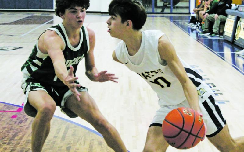 Perrin’s Jack McCormick (10) looks to drive the baseline but the Breckenridge defender has other ideas. The Pirates came back from 12 points down in the fourth quarter and seven points behind in the first overtime, but wound up losing 77-74. Photo/Brian Smith