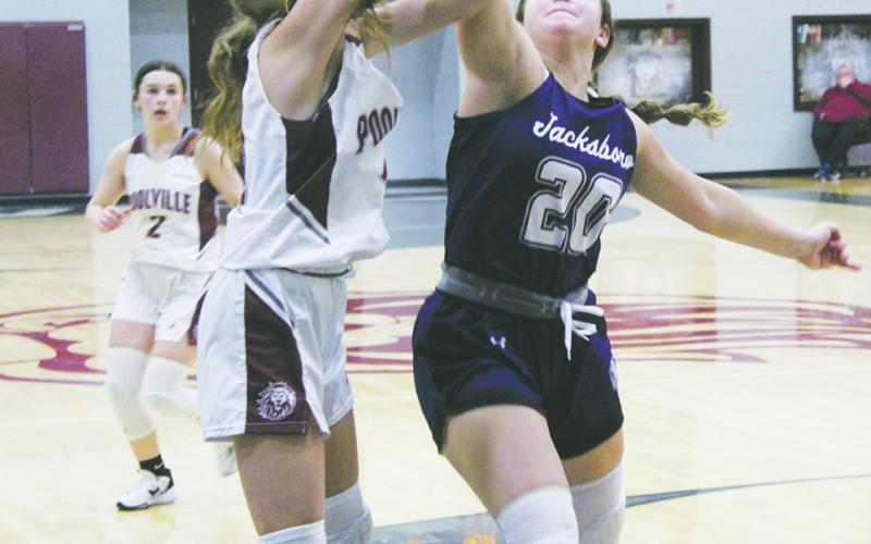 Jacksboro senior Avery Bennett (20) attempts to block a Poolville shot during first half action Tuesday, Dec. 6 against the Lady Monarchs. Photo/Brian Smith