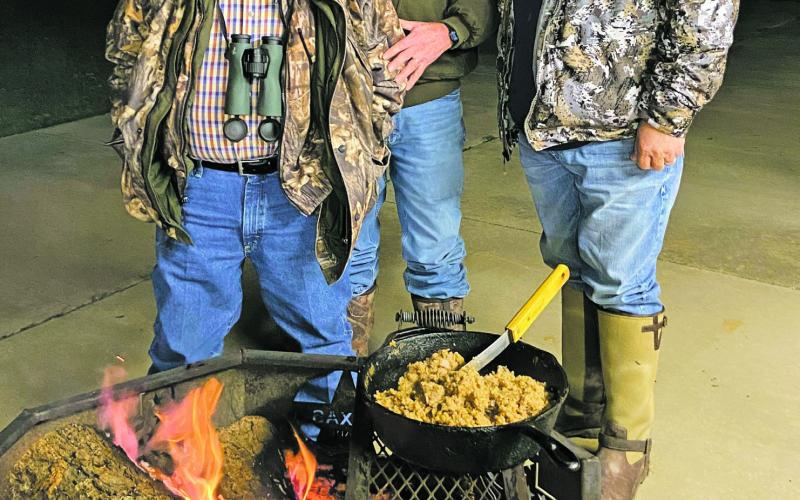 Edgar Cotton, left, Luke Clayton, center, and David Cotton, right, bond over a meal of venison steak, rice, and gravy. Courtesy photo