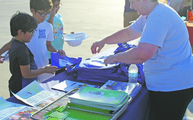 Melanie Belcher, right, was one of the many vendors at National Night Out Oct. 4 at Jacksboro Middle School. Belcher, representing Faith Community Hospital, is putting together safety and coloring kits for the kids. Photo/Brian Smith