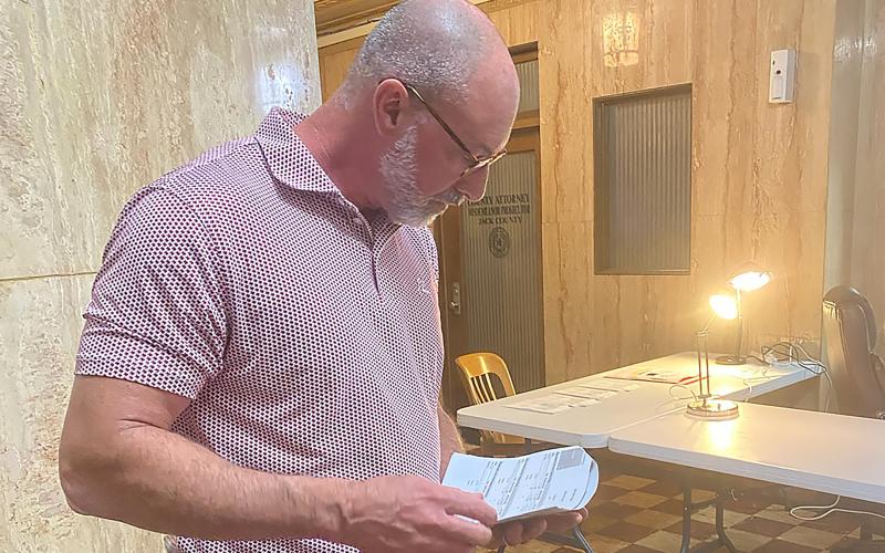 (BRIAN SMITH | JACKSBORO HERALD-GAZETTE) Republican County Chairman John Berry looks over early voting results at the Jack County Courthouse on election day.