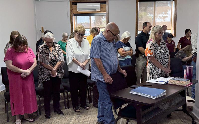 Jack County elected officials and courthouse staff gather in the commissioners courtroom Monday, Aug. 4 to pray for the recovery of Constable Clyde Watson. The county agreed to hire a deputy constable to work through the backlog of cases. Photo/Ashley Anderson