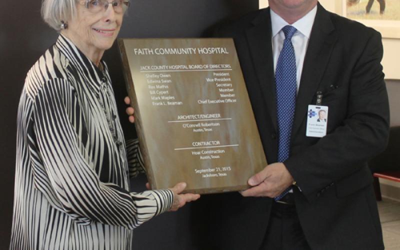 FCH Board Member Edwina Swan, left, and FCH Administrator/CEO Frank Beaman hang the dedication plaque in the lobby of the hospital during Saturday's dedication.