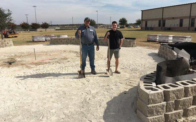 Greg Lewis, owner of GAL Horticultural Services, and Texas FFA Ford Leadership Scholar, Hunter Hackley, inspect construction of the JHS Memorial Courtyard.  