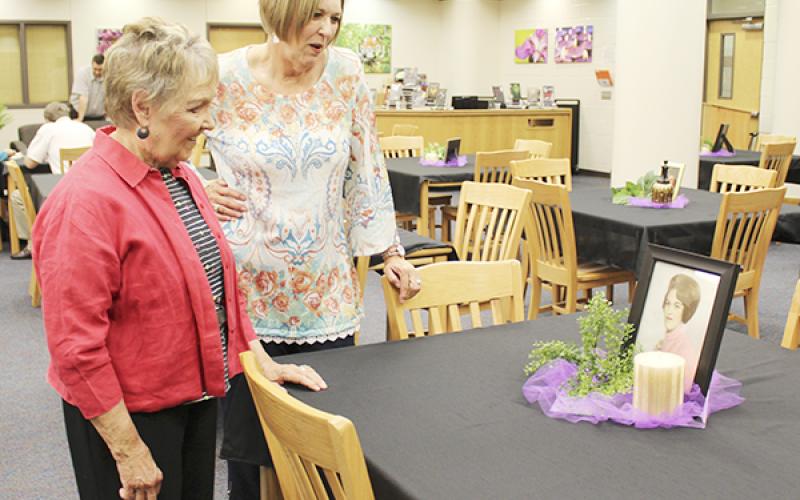 Ann Kaker, former second grade teacher, and Diana White admire a photo of White from high school during the retirement reception Monday at the Jacksboro High School library.  Photo / Cherry Rushin