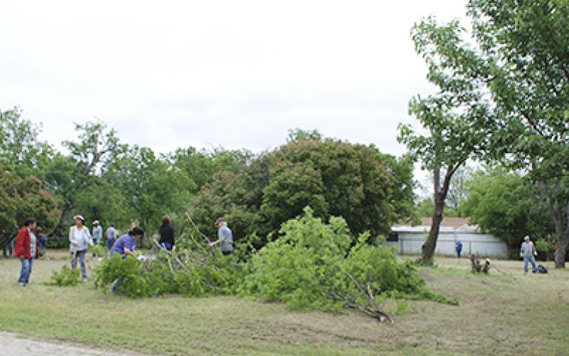 Volunteers clean up the lots at the southwest corner of South 3rd and Pine streets Saturday. Approximately 25 to 30 people came out to trim trees, clear brush, mow and more for the site of Jacksboro’s soon-to-be newest park. Courtesy / Terry McDaniel