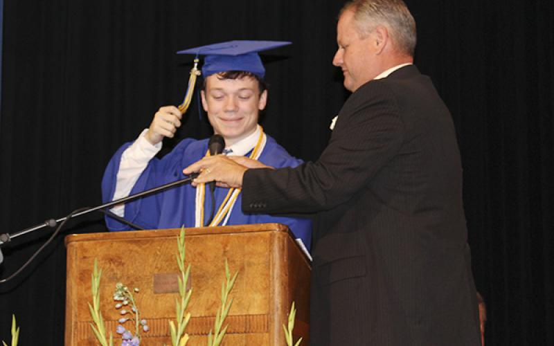 Bryson Superintendent David Stout adjusts the microphone for Salutatorian Jacob Jonas before he gives his address.