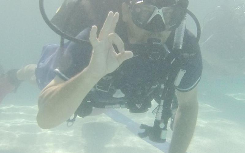 John Moffit gives an OK sign during dive training last weekend at the city pool. Moffit and four other firefighters are training for diving certification.