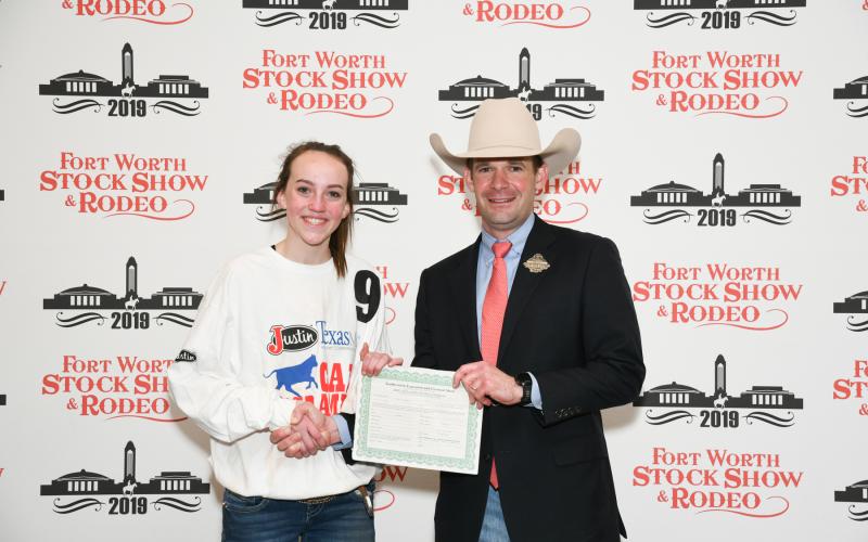 Abigail Mangum, Jack County 4-H member, caught a calf during Fort Worth Stock Show and Rodeo's Calf Scramble, earning a $500 purchase certificate presented by Paxton Motheral, calf scramble committee member. 