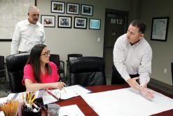 Representatives from KWA Engineering and Building Science Company present preliminary plans to rebuild the agricultural facility at Bryson ISD. Pictured (front, from left) is Bryson ISD School Board Assistant Secretary Shelby Letherwood, KWA Engineering Principal and Vice President Brad Draper and (back) KWA Engineering Design and Construction Services Manager and architect Darren Densford. Photo/Ashley Anderson