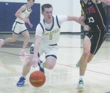 Hunter Walker (1) drives past a defender during a recent game. The Pirates opened district play with a 44-35 win over Woodson. File photo
