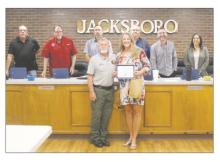 Jacksboro High School college prep teacher Hillary Deffebach receives congratulations and awards from Animal Control Officer Mike Booher during the Monday, April 28 city council meeting. Deffebach and her students do community service work for a number of community organizations. Photo/Brian Smith