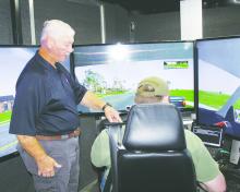 Don Courtney with the Texas Association of Counties speaks to Jack County Sheriff’s Deputy Cole Peace as he prepares to take part in a driving simulation. All JCSD deputies took part in the two-day event. Photo/Brian Smith