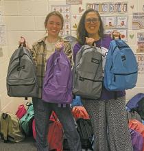 Jacksboro Elementary School counselor Teresa Howard, right, accepts a donation of 35 backpacks from Jacksboro High School student Allie Robinson. Robinson developed the community service project as an attempt to avoid the summer slide for students. Photo/Brian Smith