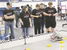(Top) Bryson senior Jackson Eberle drives the robot for Bryson 1 during the Bryson robotics competition Saturday, Jan. 28. Bryson 1 won the competition against larger schools from Iowa Park, Burkburnett, Fort Worth and Gordon. (Bottom) Burkburnett’s Peyton Edwards (left) and Michael Bentley work on their robot’s “hiccups” as part of the competition. Photos/Brian Smith