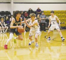 Bryson’s Wiett Newton (14) plays defense on the Millsap ballhandler during the Cowboys’ game with the Bulldogs. Photo/Brian Smith