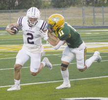 Tiger Quarterback Lando Belcher, who has thrown for 1,510 yards in the first half of the season, looks to escape from a Boyd defender in the Tigers’ 48-45 win Sept. 1. Belcher and the Tigers open District 5-3A Division II play Friday in Eastland. File photo