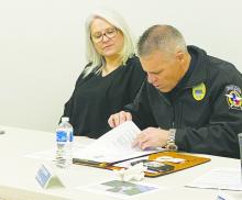 Jacksboro Police Chief Scott Haynes, right, looks over a report on racial profiling during the city council meeting March 13. The department had no complaints on racial profiling in the report. Photo/Brian Smith