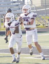 Jacksboro’s JV Purple quarterback Wyatt Gavit looks for an open receiver with Josh Salazar providing blocking. The Tigers remained perfect in district play with a win over Merkel. Photo/Brian Smith