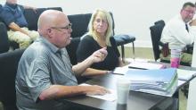 County treasurer Brad Campsey answers a question on the bills for a commissioner while county auditor Lisa Perry looks on. Commissioners discussed what to do about a problem with flooding on the third floor of the courthouse. Photo/Brian Smith