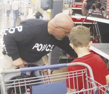 Jacksboro Police Department Sgt. Houston Gass, top, and Teresa Howard help their students make selections during Shop with a Cop. Jacksboro ISD students had the chance to go shopping for Christmas items. Thursday, Dec. 19. Students were given a $200 Walmart gift card, of which half must have been spent on clothes and necessities. Photos/Brian Smith
