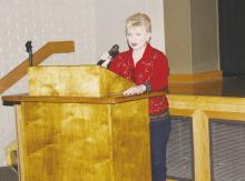 Harva Kuykendall with the Tornado Long Term Recovery Committee speaks at the Night of Reflection on the work the committee is doing. Photo/Brian Smith