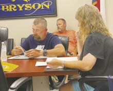 Bryson ISD board members Blake Brooks, left, and Sheila Birdwell, go over the bills during the meeting Monday, June 17. The board discussed but made no decision on dress code changes. Photo/Brian Smith