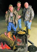 Edgar Cotton, left, Luke Clayton, center, and David Cotton, right, bond over a meal of venison steak, rice, and gravy. Courtesy photo