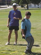 New Bryson Coach Noah Sprinkle look at a summer conditioning athlete’s technique during an agility drill last week. Photo/Brian Smith