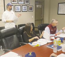 Brandon Westlake, center, speaks to the Bryson ISD board about changes to the application to the solar farm in the district during a Monday, Dec. 16 meeting. The changes were approved. Photo/Brian Smith