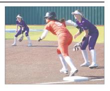 Jacksboro’s Brooke Reaves (right) and Holly Lehman keep and eye on the Springtown baserunner. Jacksboro gained a split of games played at Weatherford.