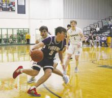 Jacksboro senior Ryder Jackson (5) drives to the bucket past the Iowa Park defender during first quarter action Tuesday, Jan. 10 with the Hawks. The Tigers fought hard, but suffered a 50-43 loss. Photo/Brian Smith