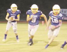 Chance Hand, with ball, gets blocking from Noah Justus (9) and Gavin Sadler (15) during the Cowboys’ 74-27 win Friday, Oct. 6 over Lingleville to open District 9-A play. Photo/Brian Smith