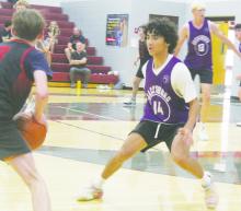 Damian Salazar (14) plays defense on a Mineral Wells player during second half action. The Tigers ended Poolville Summer League action with a 40-32 win over the Rams.
