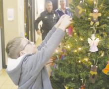 A kindergartner hangs an ornament Thursday, Nov. 30 during Christmas with the Cops at Jacksboro Police Department. Photo/Brian Smith