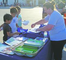 Melanie Belcher, right, was one of the many vendors at National Night Out Oct. 4 at Jacksboro Middle School. Belcher, representing Faith Community Hospital, is putting together safety and coloring kits for the kids. Photo/Brian Smith