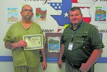 Warden Brian Collins, right, is seen with inmate Fred Lewis, one of the art contest winners. Courtesy photo