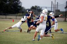 Cole Keeney carries the ball away from defenders Friday, Sept. 12. Keeney was a force offensively for the Pirates in their win over the Wildcats. Photo/Ashley Anderson