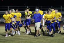 Cowboys head coach Kevin Ray heads to the sideline after speaking to his players Saturday, Aug. 9. Ray said he hoped to create a memorable experience for players during midnight madness practice. 