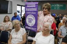Jacksboro Sesquicentennial Celebration committee volunteer Roxanna Maddox shows off commemorative banners to be displayed on light poles around the courthouse square ahead of the two-day event, Friday and Saturday, Sept. 26-27. Photo/Ashley Anderson