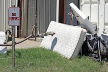(Photo/Ashley Anderson) Old mattresses and playground equipment are tossed out at the Jack County Clothes Closet, even though signs state no illegal dumping, broken furniture or trash.