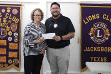 Jacksboro Lions Club President Chris McBride presents a donation to Concerned Citizens of Jack County Executive Director Russona Jones-Briscoe at the club’s Wednesday, Nov. 12 meeting. Concerned Citizens provides hot meals, programs and activities for seniors and disabled residents in Jack County. Photo/Ashley Anderson