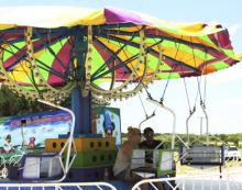 Carnival workers take a break from the heat Wednesday afternoon when they were preparing to open at Twin Lakes Thursday. The carnival is a new addition to the TNT Fest event which is set for Saturday. 