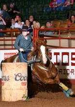 Mika Shackelford makes her way around a barrel during a rodeo competition.